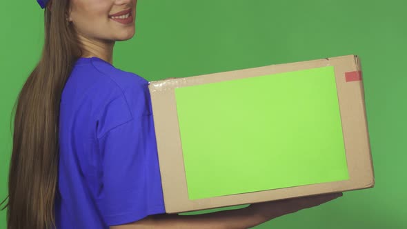 Cropped Rearview Shot of a Smiling Delivery Woman Holding Cardboard Box