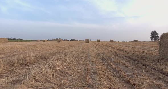 Aerial Footage Above a Hay Field with a Stacks of Hay