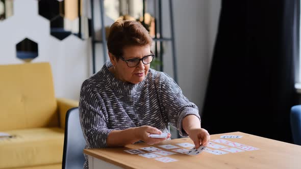 Senior Woman Playing Solitaire at Home