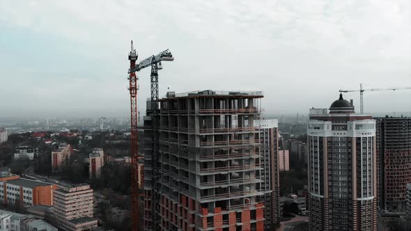 High Crane Near Unfinished Building in Industrial City with Skyscrapers