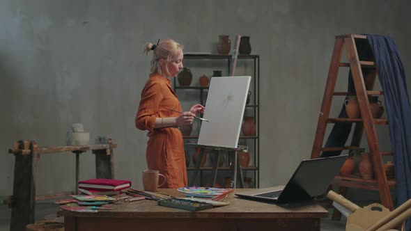 Female Artist Teaching Art Lesson Online in Workshop