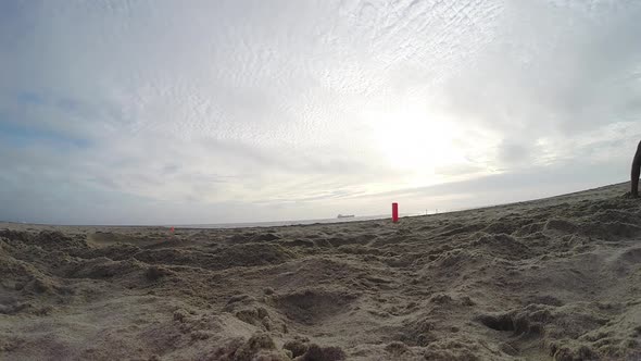 A group of young men playing flag football on the beach.