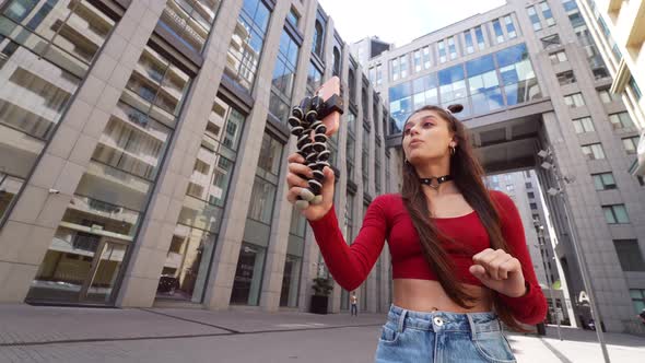 Young Female Blogger with Smartphone Streaming on the Street