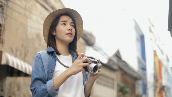 Portrait Beautiful hipster woman wearing retro fedora hat use film camera taking a photo.