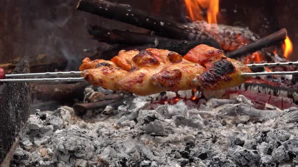 Mouthwatering Chicken Wings on the Skewers Are Roasting Above the Open Fire