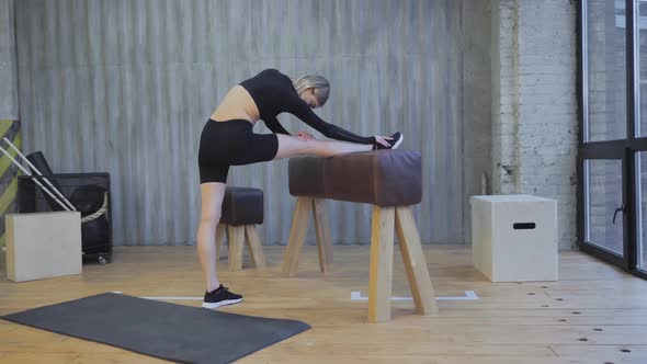 Sporty athletic woman does sports and yoga, young woman exercising on gymnastic wall bars