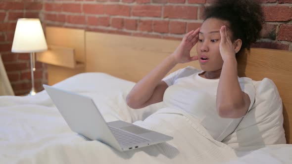 African Woman Having Headache While Working on Laptop in Bed
