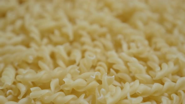 Pieces of spiral pasta ready to be cooked close-up slow tilt 4K 2160p 30fps UltraHD footage - Girand