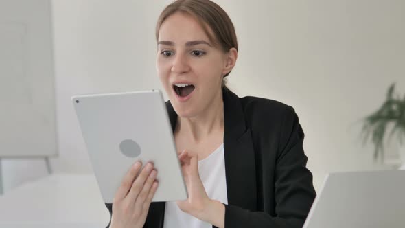 Young Businesswoman Celebrating Success on Tablet