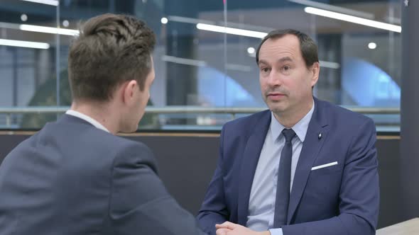 Rear View of Businessman Talking to Colleague