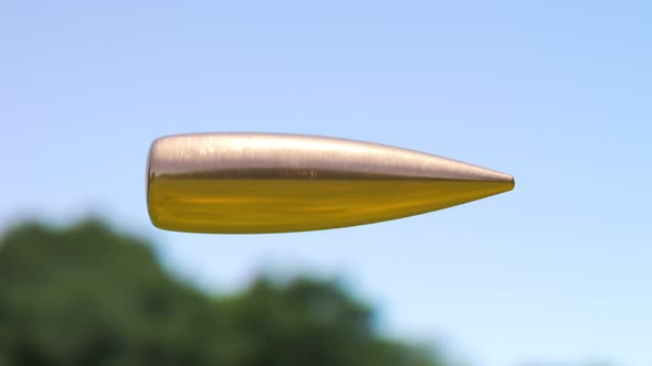 Slow motion shot of a bullet travelling through the air. Looping animation. 4KHD