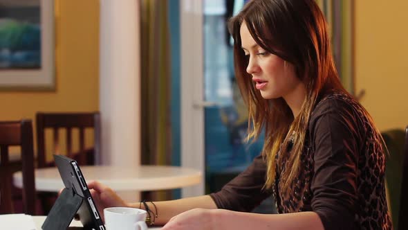 Beautiful Attractive Young Woman Reads News in Tablet PC Office