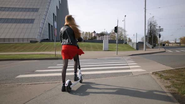 Yound Woman Crosses Road on Green Light Riding Electric Scooter