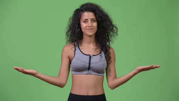 Young Beautiful Hispanic Woman with Gym Clothes Having Decisions