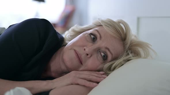 Worried Old Woman Thinking While Sleeping in Bed