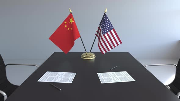 Flags of China and the United States and Papers on the Table alt