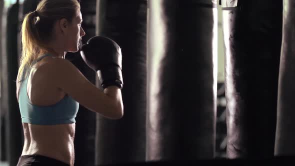 Woman does Muay Thai kickboxing training at the gym.