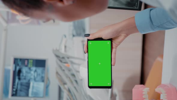 Vertical Video Woman Holding Smartphone with Horizontal Green Screen