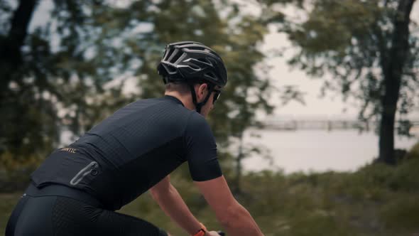 Cyclist Riding On Road Bike In Park And Getting Ready For Triathlon.Hard Training.Triathlete Cyclist