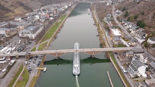 aerial view of a barge passing the bridge over the river mosel in the german city of cochem in rhein