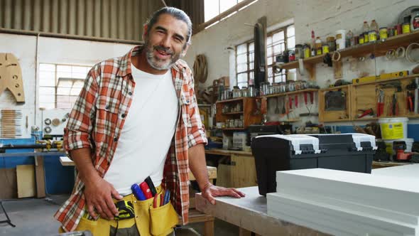 Smiling carpenter fixing the camera