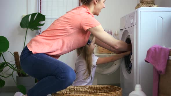 Mother Help Young Daughter Load Dirty Laundry in Washing Machine Spbd