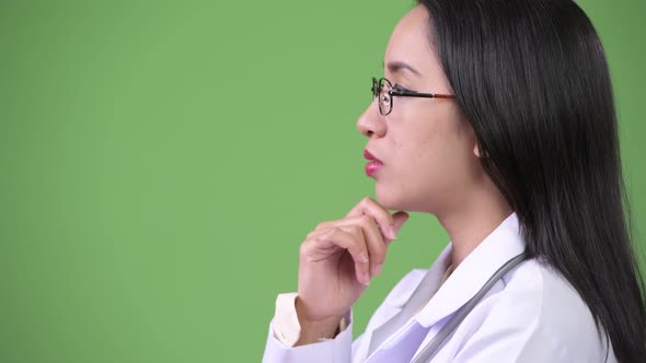 Profile View of Young Beautiful Asian Woman Doctor Thinking