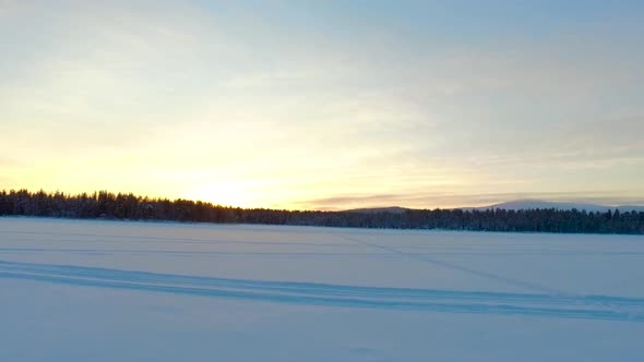 Aerial view of a winter landscape with forests and mountains at sunset in Gällivare, in northern Swe