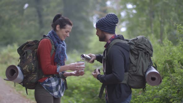 Couple drinking water in forest area