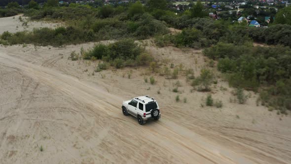 Aerial View of a Car Driving on Sand