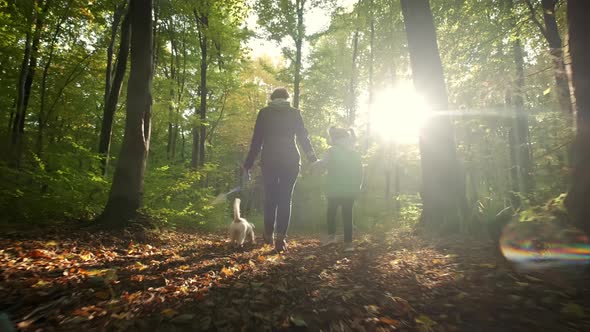 Woman with Little Daughter Walking the Dog in the Forest