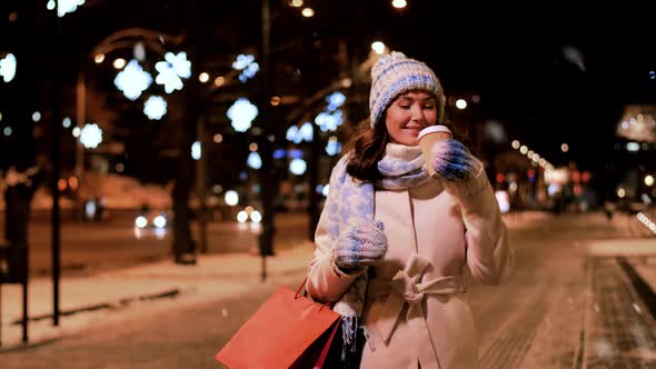 Happy Woman with Coffee and Shopping Bag in Winter