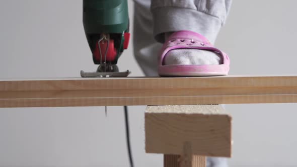 Beauty of Slow Motion in Construction and Repair - Man Sawing a Wooden Board with an Electric Jigsaw alt