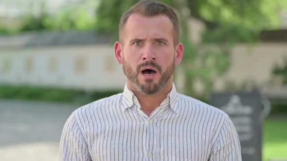 Outdoor Portrait of Disappointed Middle Aged Man Reacting Loss