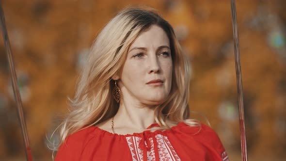 Feisty Beautiful Woman in Red National Dress Holding Two Swords