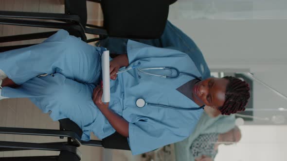 Vertical Video Portrait of African American Nurse Analyzing Checkup Papers