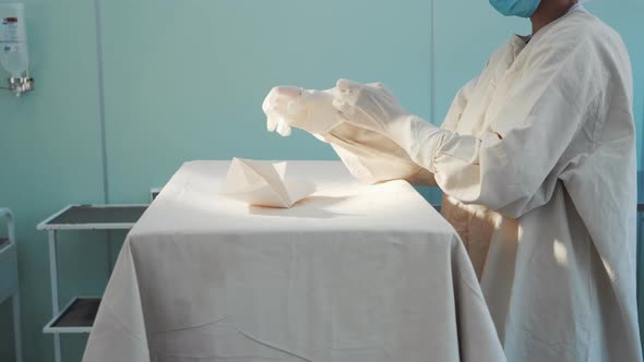 Doctor Preparing for Surgery in Operating Room Putting on Rubber Latex Gloves