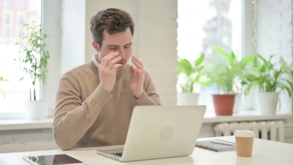 Man Having Headache While Working on Laptop