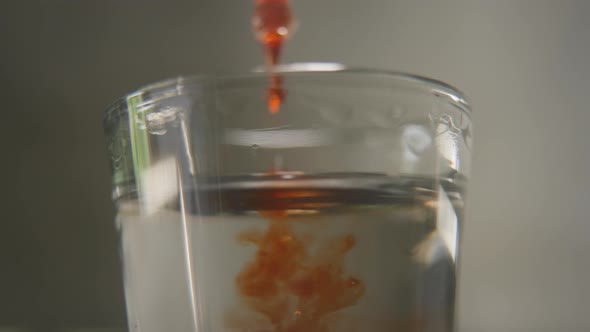 Perfumer Pouring Drops of Oily Scent Into Perfume in a Glass