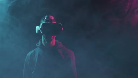 Portrait of a man in virtual reality helmet. Obscured dark face in VR goggles.