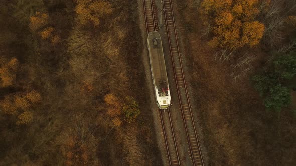 Aerial View of Modern Tram Riding Between Fields with Trees in Countryside. Bird's Eye View of