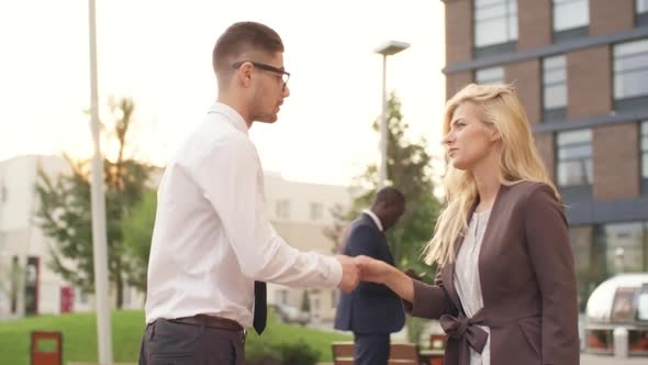 Businesspeople Shaking Hands and Talking Outdoors