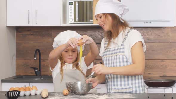 Beautiful Happy Mother and Daughter Baking Together in Kitchen