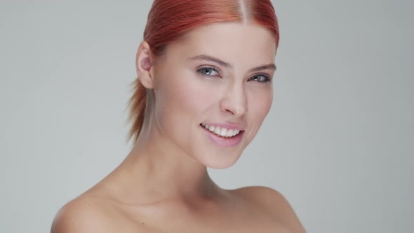 Studio portrait of young, beautiful and natural redhead woman. Beauty concept.