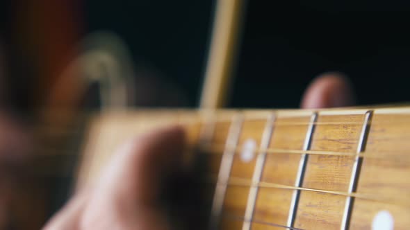 Musician Plays Brown Acoustic Guitar and Improvises Closeup