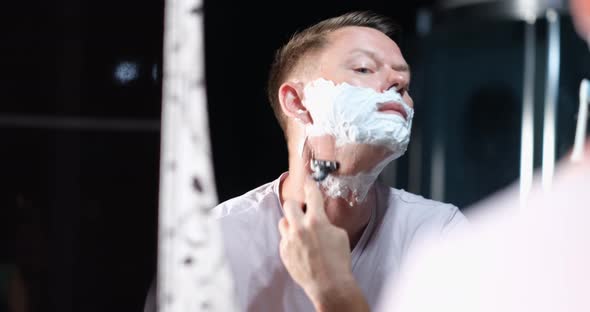 Handsome Man with White Foam Shaves Hair