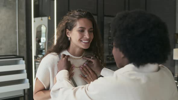 Consultant Offering Necklace to Woman