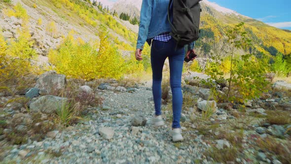 young tourist walks through mountainous area and looks at beautiful landscape.