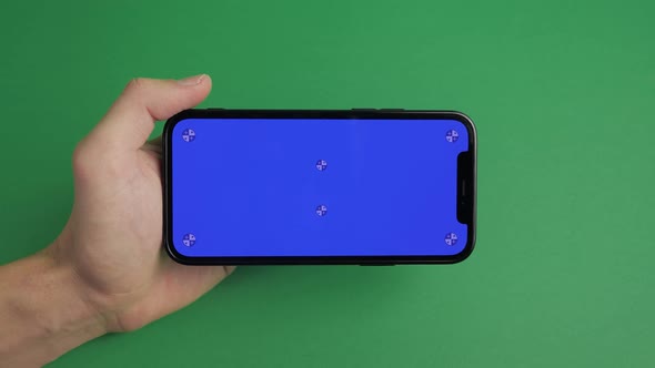 Closeup of Male Hand Holding Mobile Telephone with Horizontal Blue Screen Chroma Key Smartphone