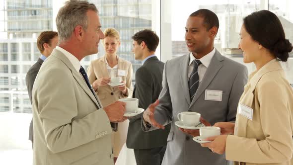 Business people chatting at a conference having coffee